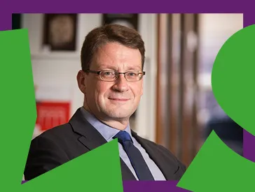 Photo of a man with dark hair, glasses, suit and tie, looking friendly into the camera, around it a purple frame and the green inscription: Lecture Series.