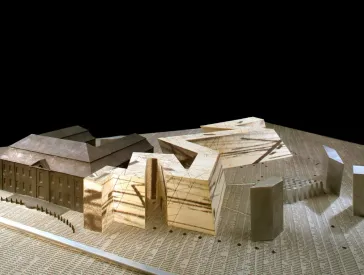 Architekturmodell des Jüdischen Museums Berlin aus Holzwerkstoff und Karton mit bedrucktem und grau gefärbten Papier beklebt, auf dem Untergrund stehen viele Namen.