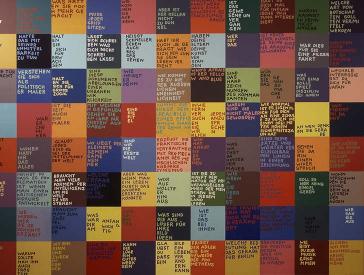Wand mit beschrifteten quadratischen Farbflächen