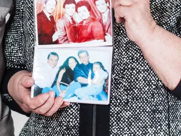 Eine Person hält auf Brusthöhe zwei Fotos in die Kamera, Gesicht und Beine der Person sind nicht zu sehen