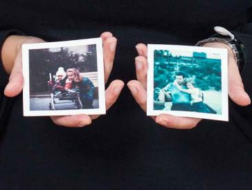 Two hands hold two color photographs.