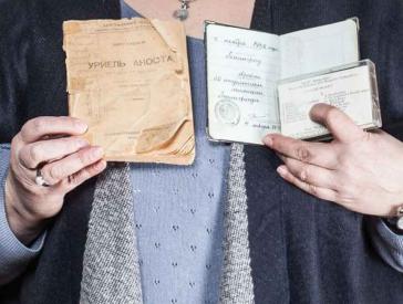 A woman shows a passport and other documents.
