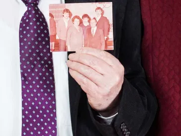 Älteres Ehepaar mit einer Fotografie in Händen.