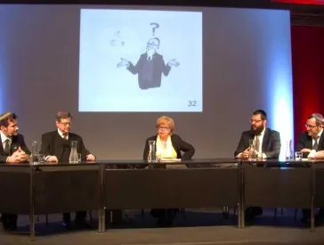 Podium mit vier M&auml;nnern und einer Frau.