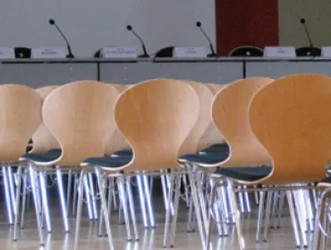 Empty chairs stand in a large hall.