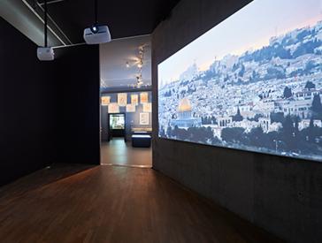 Room view: video projection of Jerusalem on a wall.