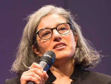 Eine Frau spricht in ein Mikrophon.