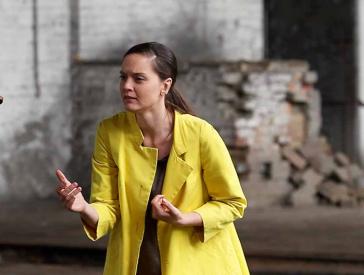 A young woman in a yellow coat.