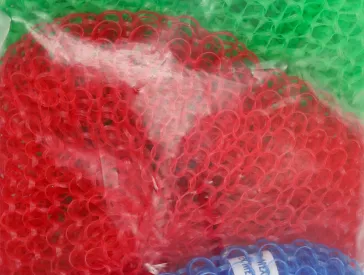 Three color-coded scrubbing brushes in their packaging.