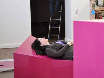 Die Kuratorin Michal Friedlander liegt auf einem der Schaukästen.