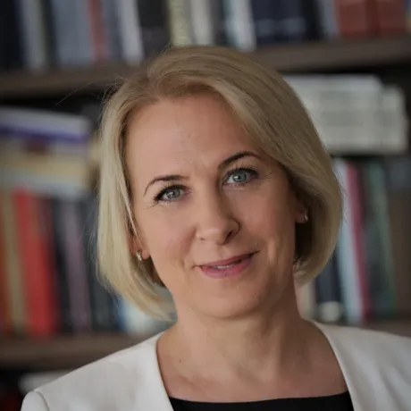 A woman with a blonde bob smiles at the camera.