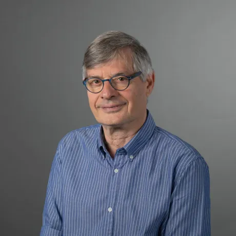 A man wearing glasses looks friendly at the camera.