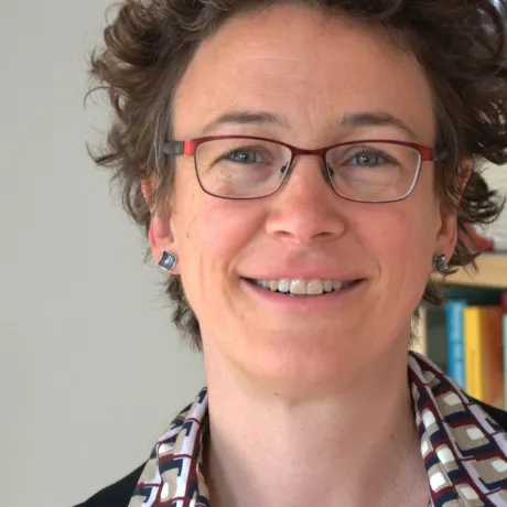 Eine Frau lacht in die Kamera. Sie tr&auml;gt eine Brille.