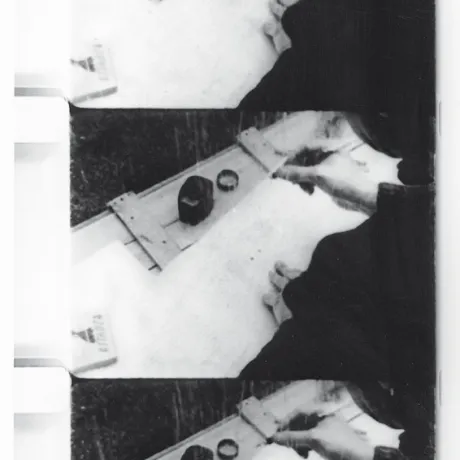 Drei Filmstills in Schwarz-Weiß mit Tintenfass und einer Hand, die einen Stift hält.