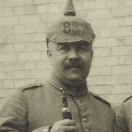 Black and white portrait of a man with a spiked helmet.