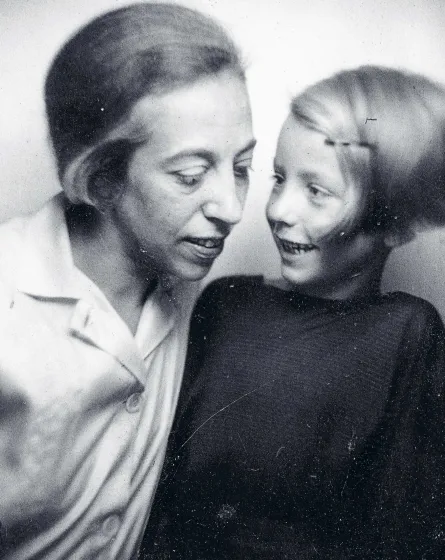  Sepia-colored portrait of a woman looking down; to her right is a child smiling at the woman.