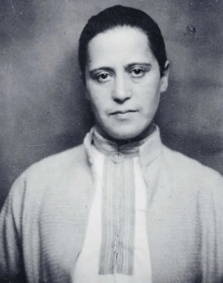 Schwarz-weiß-Fotografie einer Frau, die ein Tunika-artiges Oberteil trägt. 