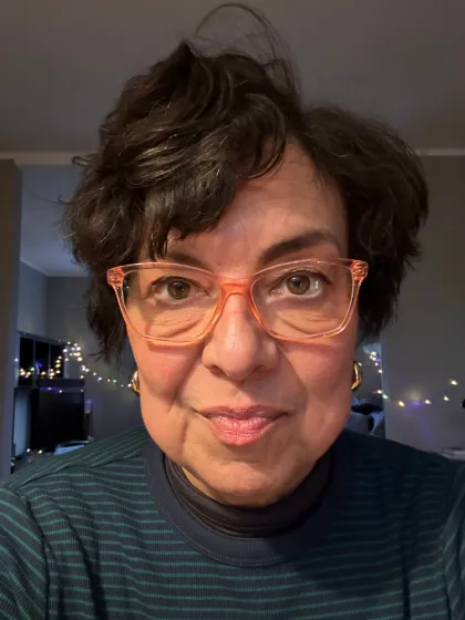 Frau mit Brille schaut freundlich in die Kamera. 