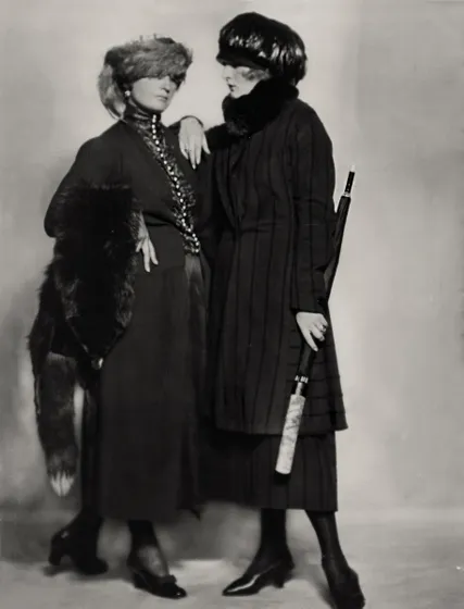 Two women wearing coats and hats.