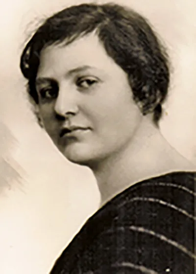 The image shows the portrait of a woman with short hair who looks diretly into the camera.