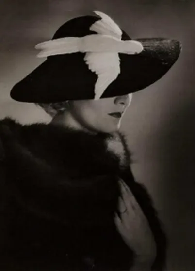 Fotografie einer Frau mit elegantem Hut aus schwarzem Samt mit weißem Vogel.
