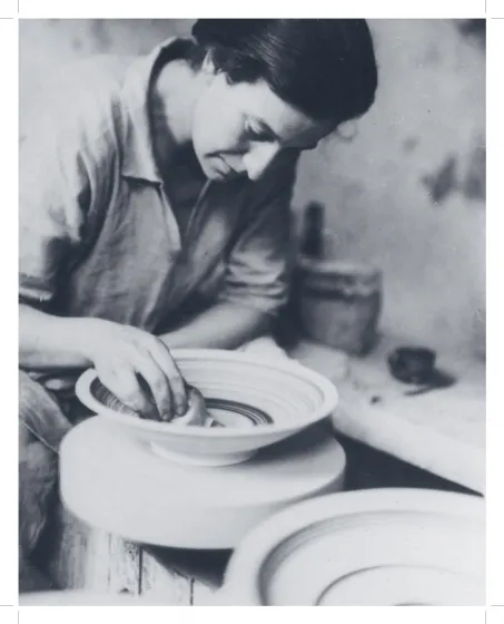 Schwarz-weiß-Fotografie einer Frau, die an einer Drehscheibe an einer töpferner Schale arbeitet.