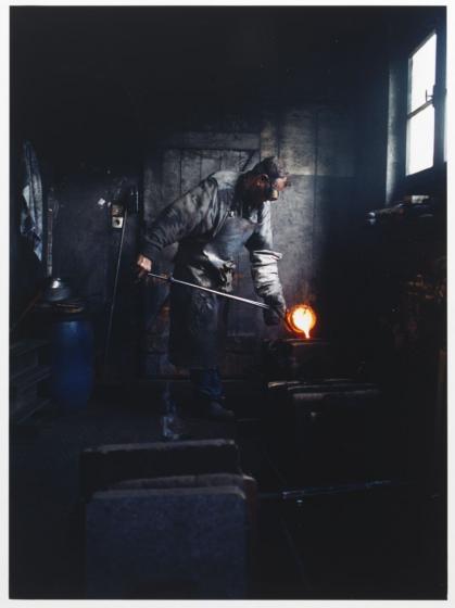 Ein Mann gießt heißes Silber in den Hohlraum der Form der Chanukka-Lampe