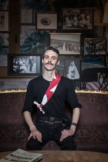 Ein junger Mann sitz in einem Raum der Ausstellung „Welcome to Jerusalem“ im Jüdischen Museum Berlin