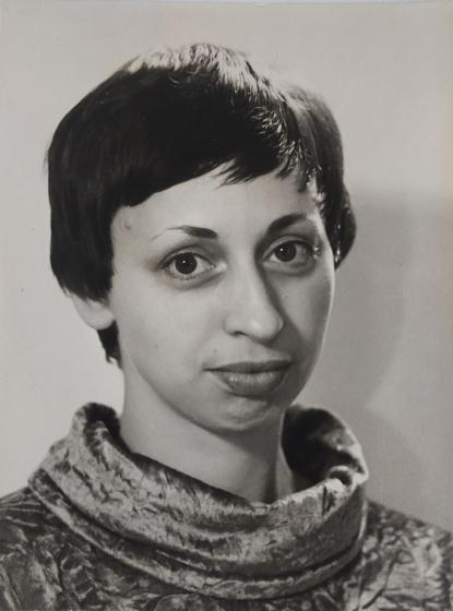 Black and white portrait of a woman with dark short hair and full lips. She looks friendly into the camera.