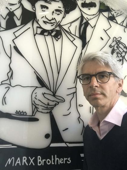 Portrait of Michael Dorrmann in front of a bust of the Marx Brothers