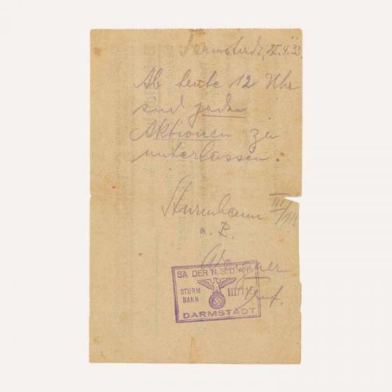 Handschriftliche Mitteilung, gestempelt und unterzeichnet von „SA-Sturmbann III/115 Wagner“. Text: Darmstadt, 25.4.1933. Ab heute 12 Uhr sind jede Aktionen zu unterlassen.“