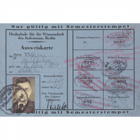Blue paper ID card with portrait photo, filled in by hand and stamped