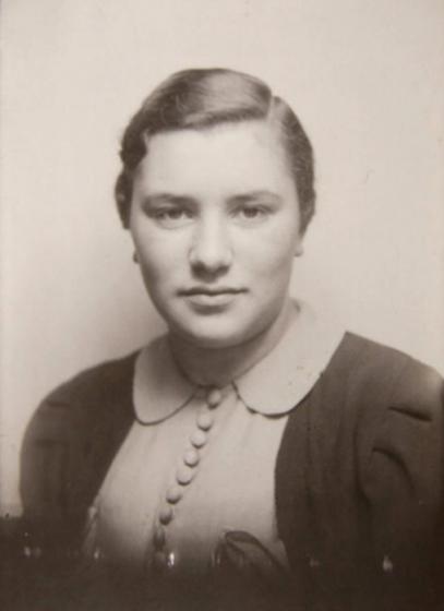 Black-and-white photograph of a young woman in a blouse and a cardigan