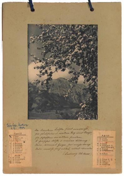 Photography: View of a calendar page with a glued-on county picture and handwritten text. 