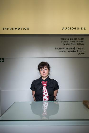 Eine junge Frau steht am Infopoint des Jüdischen Museums Berlin