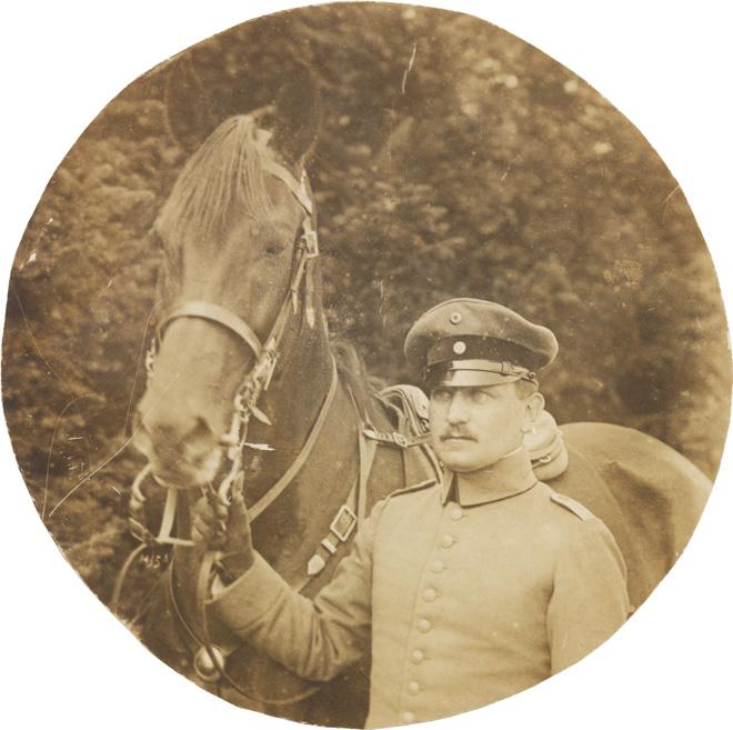 Schwarz-weiß-Foto: Uniformierter Soldat mit einem Pferd