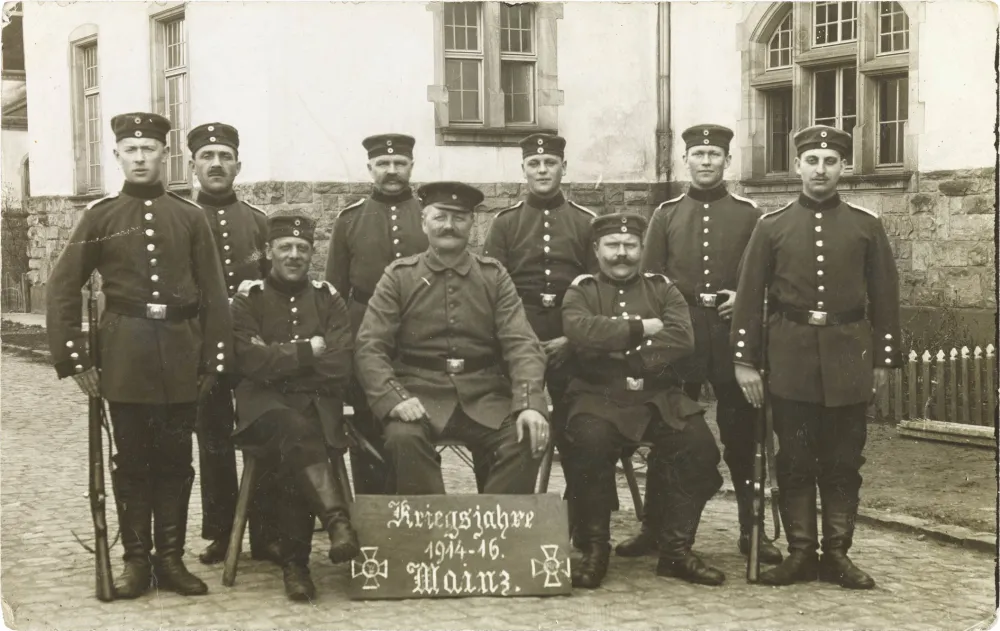 Schwarz-weiß-Foto: Neun uniformierte Soldaten vor einer Kaserne