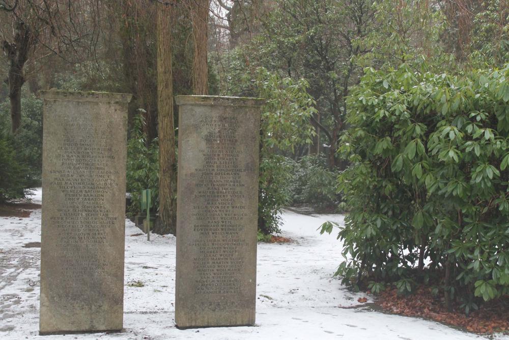 Farbfoto: Zwei Gedenksteine mit Namen von Gefallenen in alphabetischer Reihenfolge, im Hintergrund Büsche und Bäume