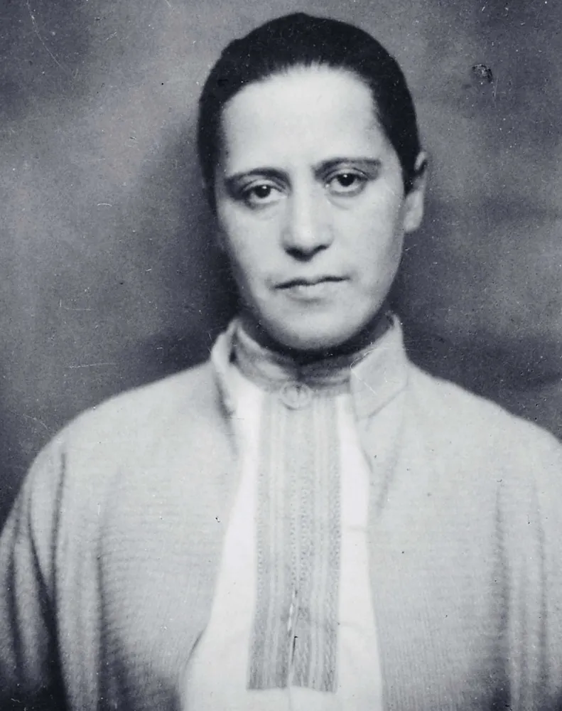 Schwarz-weiß-Fotografie einer Frau, die ein Tunika-artiges Oberteil trägt. 