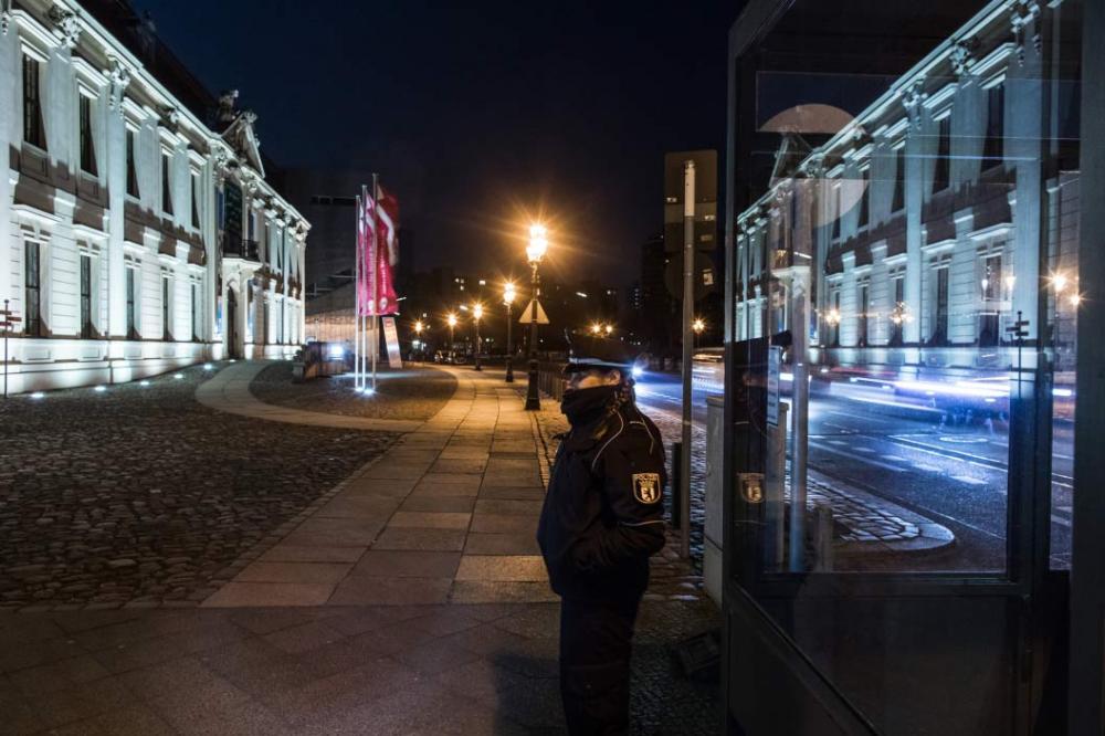 Eine Polizistin bewacht nachts den Haupteingang des Jüdischen Museums Berlin
