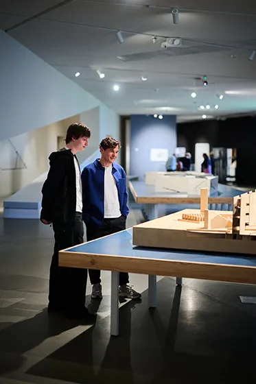 Two persons scrutinizing an architeture model.