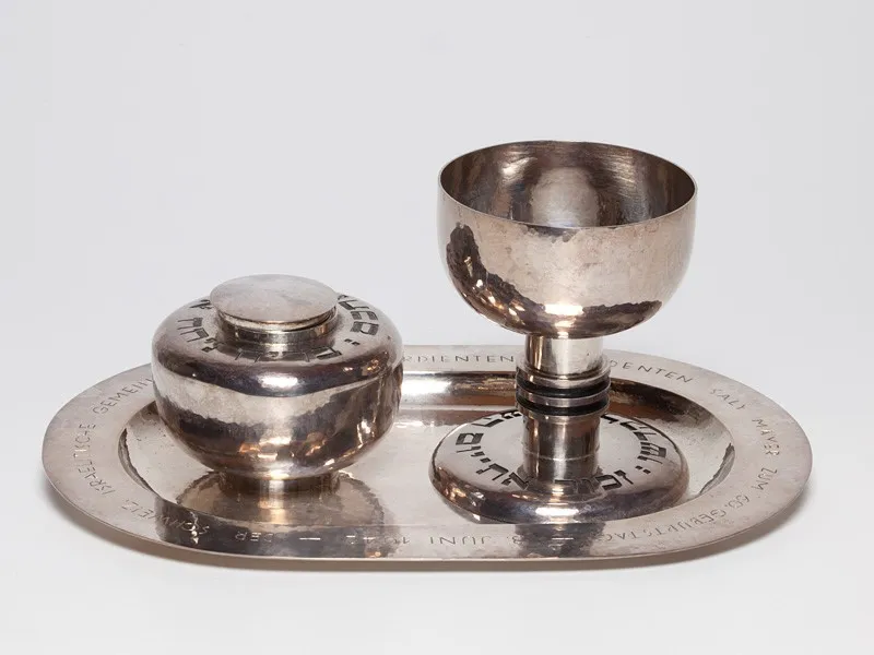 A silver tray with a box and a goblet on it.