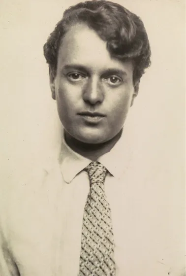  Sepia-colored portrait of a person with short hair wearing a white shirt and tie.