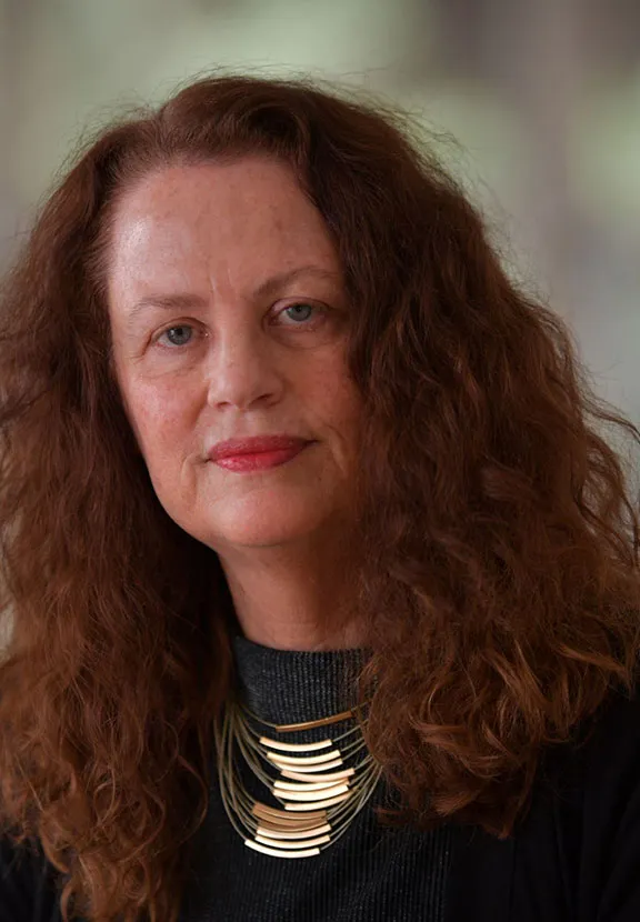 Profilfoto einer Frau mit langen, welligen Haaren, die freundlich in die Kamera schaut.