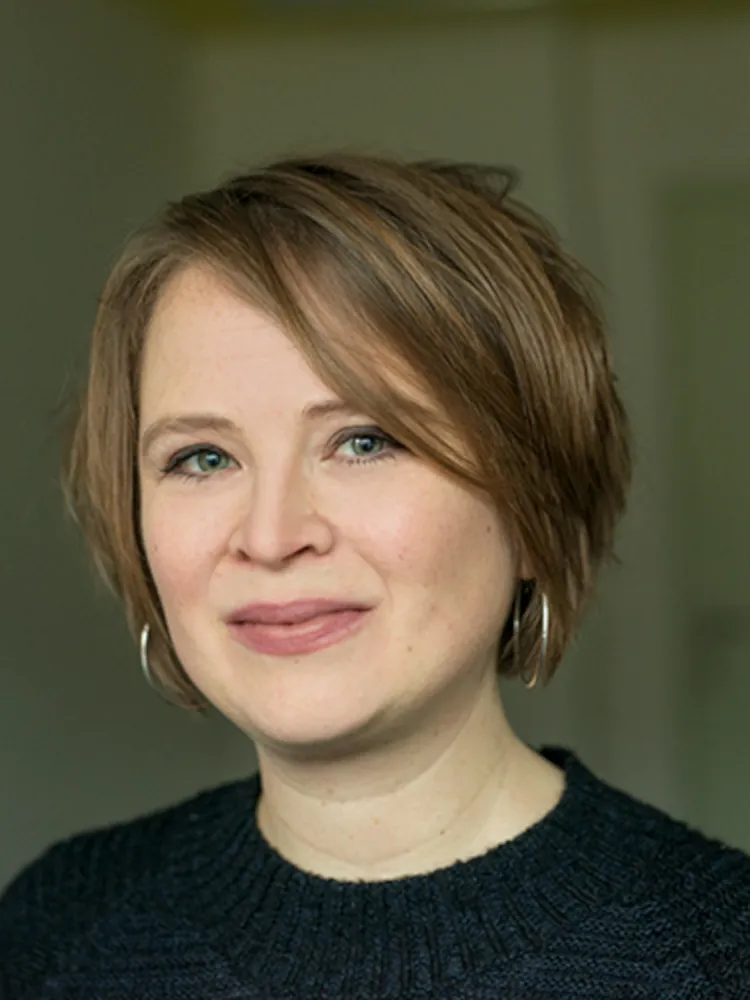 Frau schaut freundlich in die Kamera.