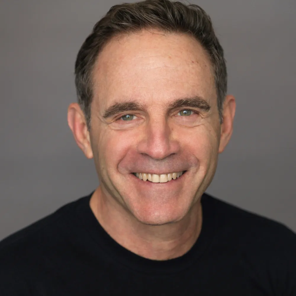 Mann l&auml;chelt freundlich in die Kamera.