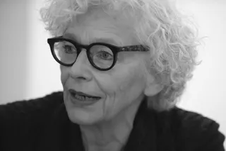 Schwarz-Wei&szlig; Foto. Portrait von einer Frau mit einer schwarzen Brille, die zur linken Seite schaut. 