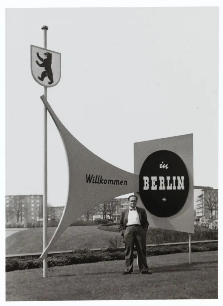 Fred Stein, behind him a sign reading &ldquo;Welcome to Berlin.&rdquo;