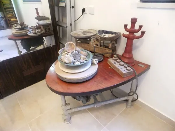 Potter's wheel on a brown table in front of a mirror