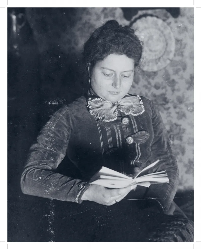 Porträt einer Frau, die ein Buch in der Hand hält und zu lesen scheint.